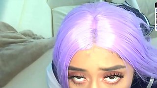 A purple-haired teenager eighteen with large baps poses in