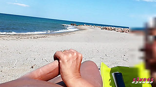 She shows her ass on the beach of Cap d'Agde and jerks off her pussy and then her boyfriend's cock with voyeurs