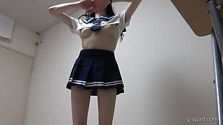 A fair-skinned japanese girl in uniform stretches her back and exposes her tits