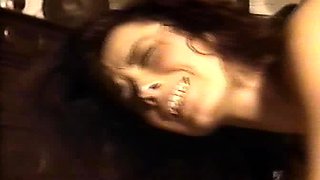 In a kitchen a sexy brunette playing with her big boobs