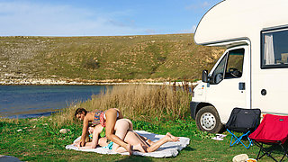 Tender beauties are passionately licking next to the lake