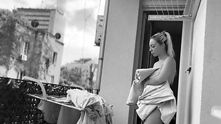 Naked chubby woman hangs out laundry on the balcony for