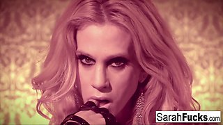 Sarah Jessie, a seductive woman wearing leather gloves, fingers herself